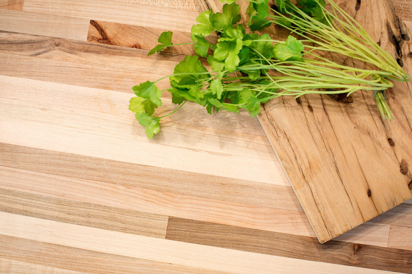 Maple countertop with a wooden cutting board and parsley
