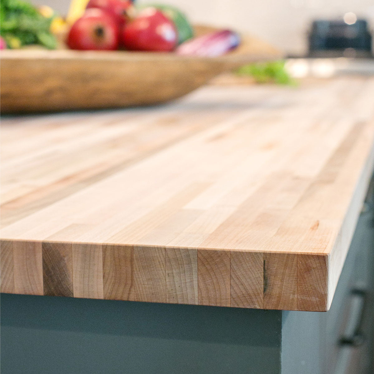 Maple countertop in with a bowl of fruit in a kitchen with dark blue cabinets