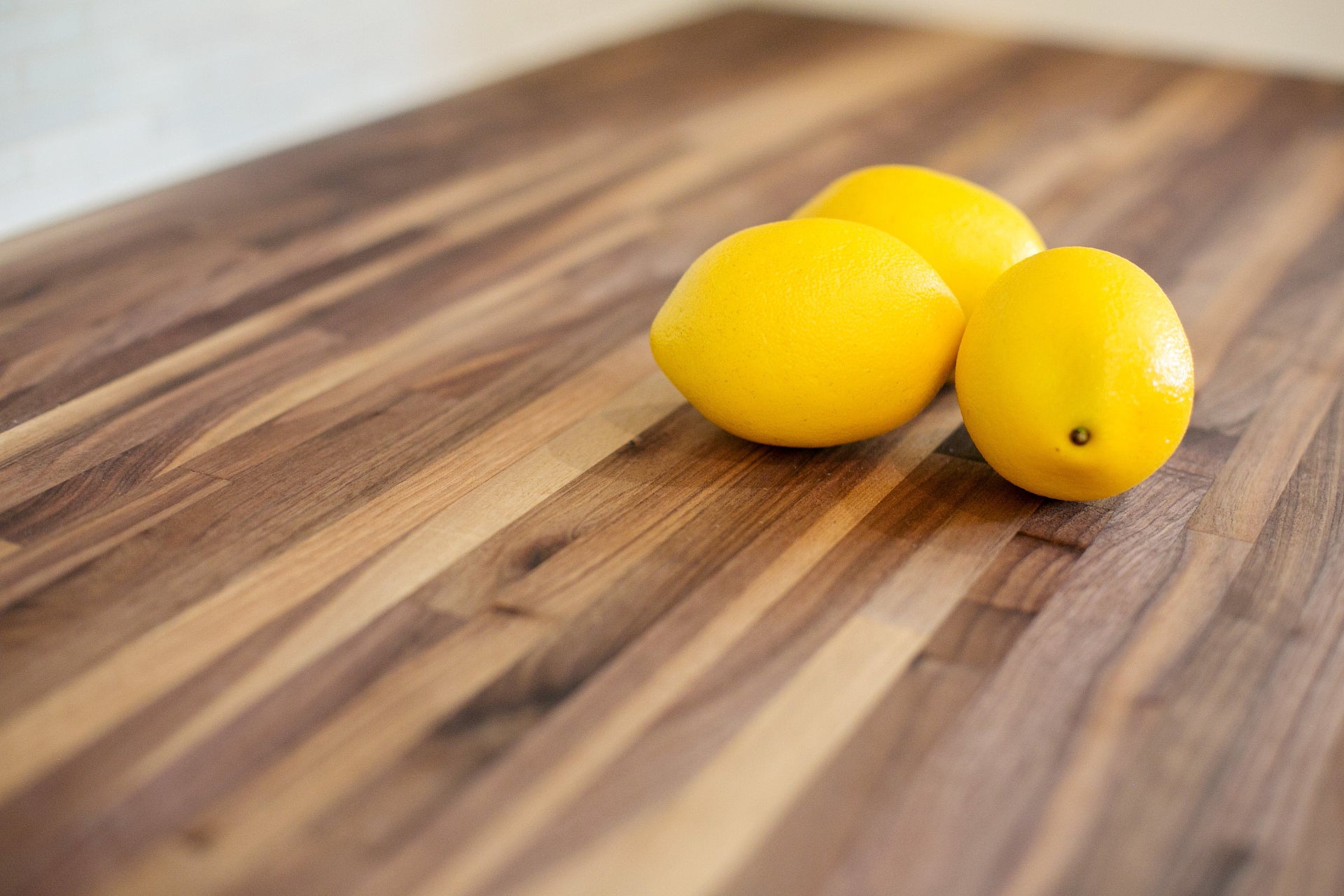 Three lemons on a walnut wooden surface